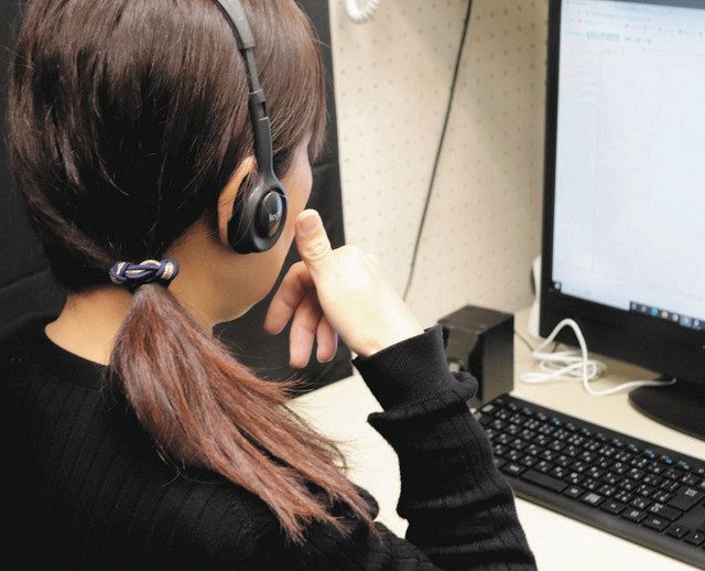 モニター画面を見ながら「電話」を手話で表すオペレーター＝滋賀県立聴覚障害者センターで

