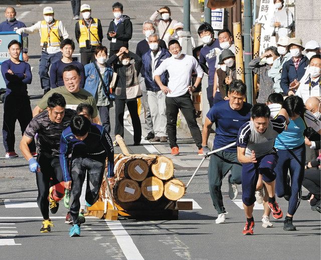 丸太を載せた木ぞりを引っ張り、ギネス世界記録に認定されたチーム「ビクトリーズ」＝３日、長野県上松町で
