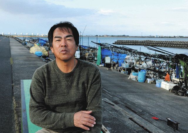 「今は前を向いて、若い組合員の生活を考えたい」と話す水谷さん。仕事場の船着き場からは、長良川河口堰が見える=三重県桑名市で