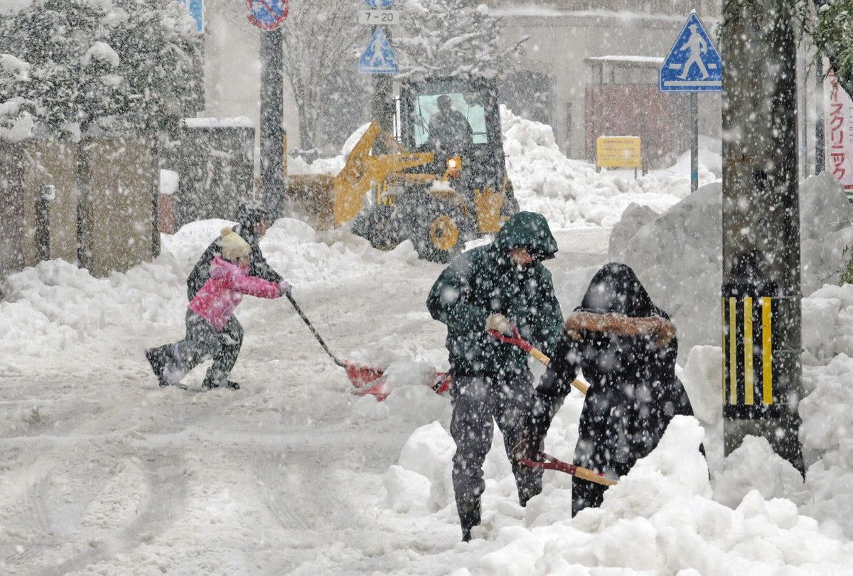 生活道路を除雪する除雪車や住民ら＝昨年１２月２３日、福井市宝永４で

