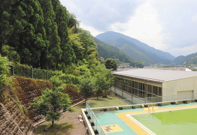 体育館のすぐそばに山肌が迫る和田小＝飯田市で
