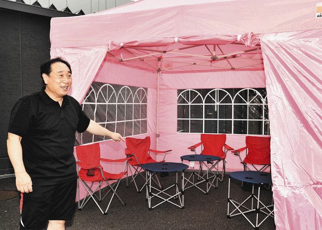 カフェで使う日よけテントや椅子、机を見せる中谷豊実さん＝名古屋市昭和区の南山高等・中学校男子部で
