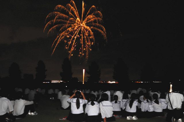 夜空に打ち上がる花火を見る生徒たち＝小松市木場町の木場潟公園で
