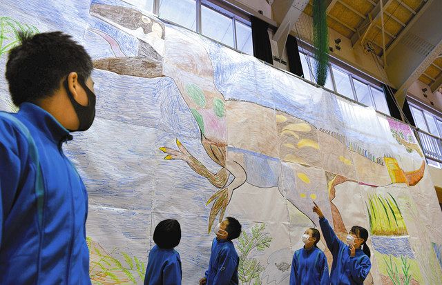 制作した巨大な恐竜の絵を見上げる生徒たち＝高山市の荘川中で
