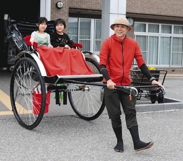 人力車を引きながら日本一周の旅を続ける福浪さん（右）＝米原市顔戸の近江学びあいステーションで