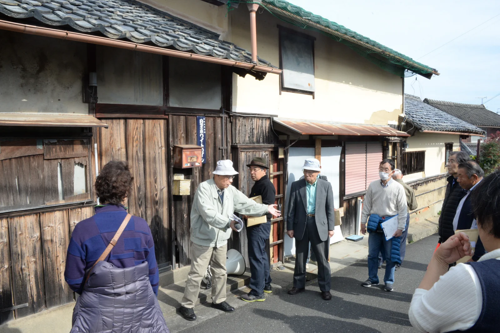 事件現場とされた「ホームラン酒店」の店舗前で、阪原さんの自白状況について説明する支援者たち