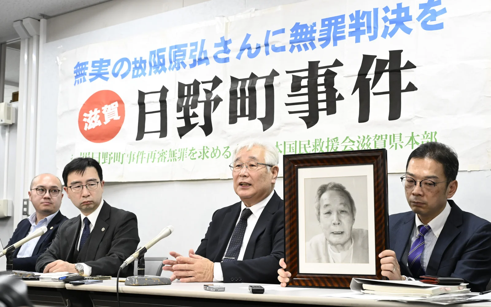 再審開始が確定し、阪原弘さんの遺影とともに記者会見する長男の弘次さんら