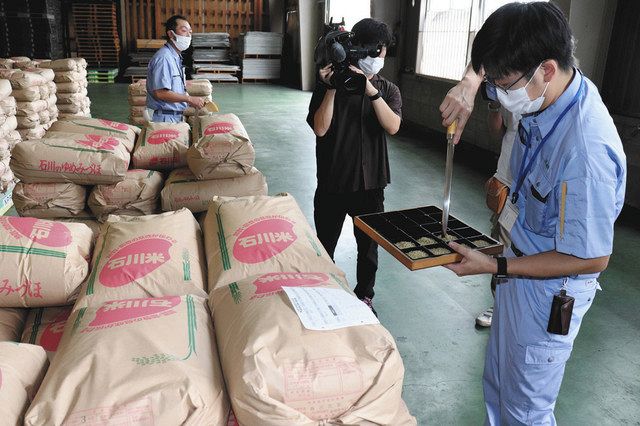 ゆめみづほの出荷前に品質を確認する検査員（右）＝加賀市作見町で 