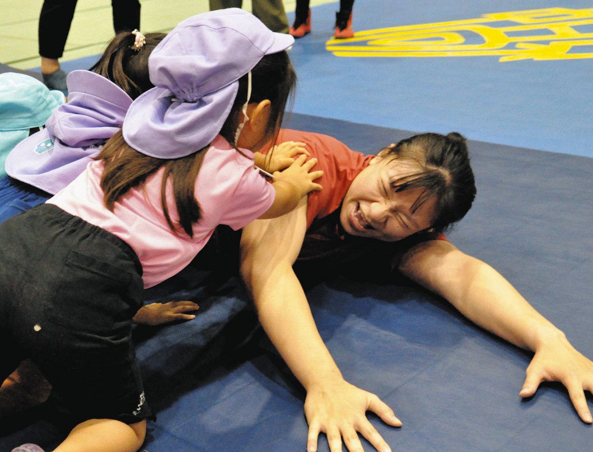 マットに伏せて防御する体勢を子どもたちに伝える張選手＝中津川市の東美濃ふれあいセンターで