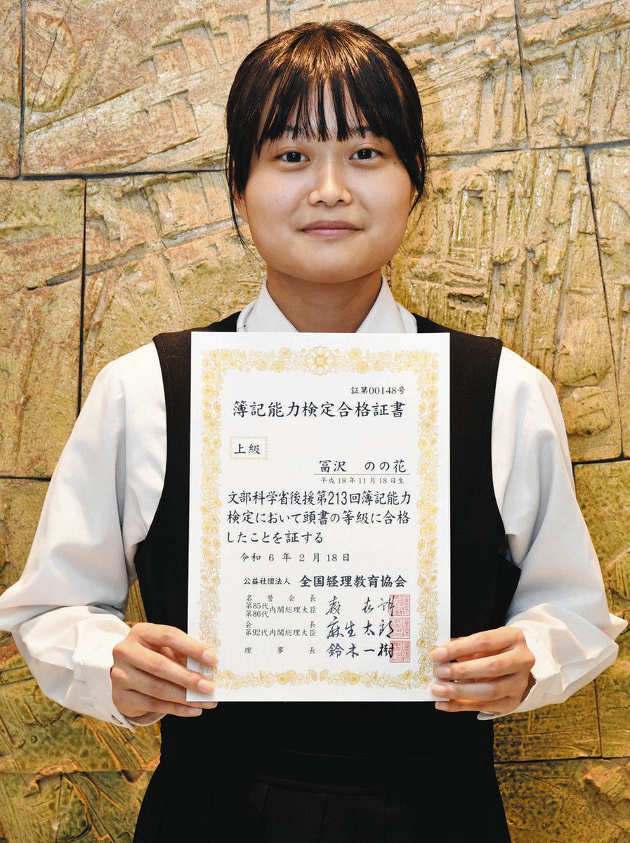 簿記能力検定上級の合格証書を持つ冨沢さん＝土岐市土岐津町の土岐商業高で