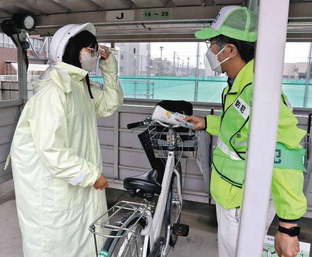 自転車で登校した生徒に鍵かけの徹底を呼びかける参加者（右）＝富山市南部中で