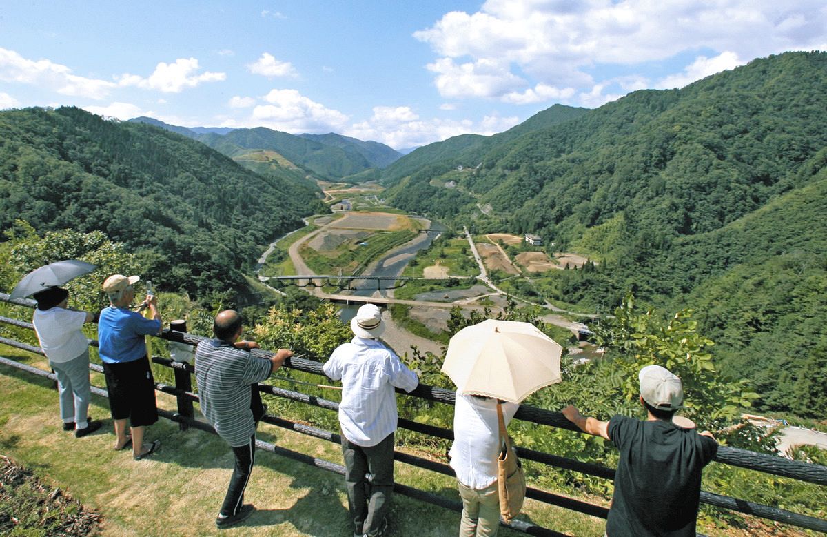 旧徳山村の中心部を山の上から見つめる住民ら＝２００６年９月、岐阜県揖斐川町で