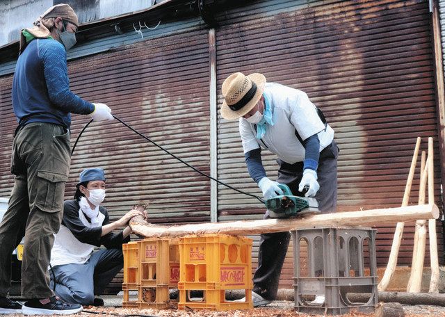 てこ棒にするためアテの木の皮を削る作業に取り組む人々＝２６日、石川県珠洲市飯田町で