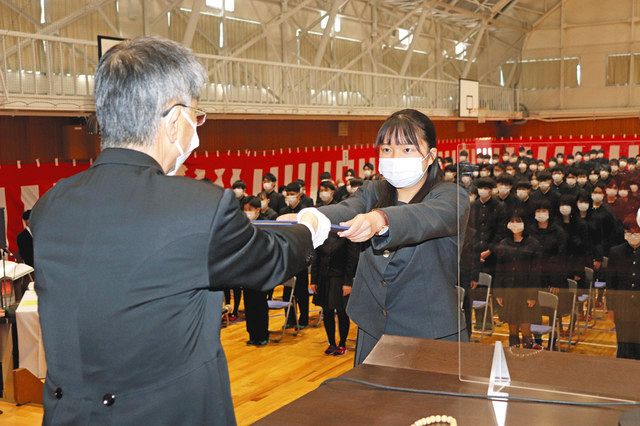 西清人校長（左）から卒業証書を受け取る普通科総代の佐藤未梨さん＝小松大谷高で 