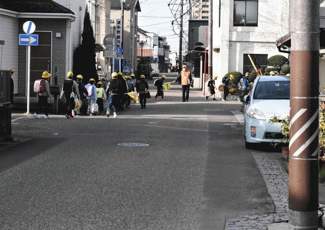 集団登校する子どもたち。この日も規制時間帯に通行する車が見られた＝春日井市鳥居松町８で 