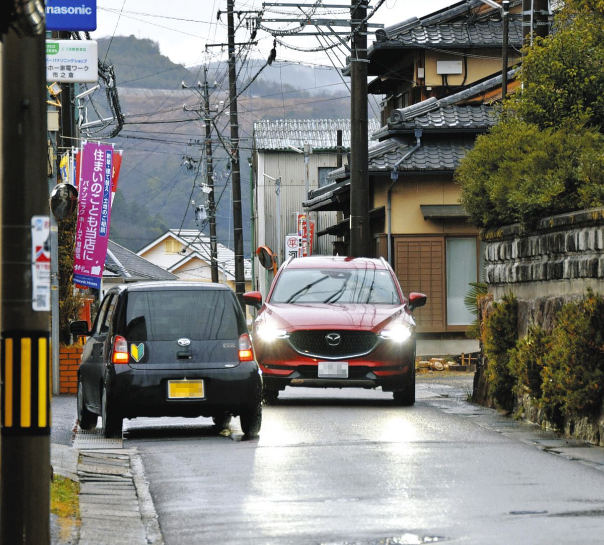 互いに譲り合って通行する車両＝多治見市市之倉町で