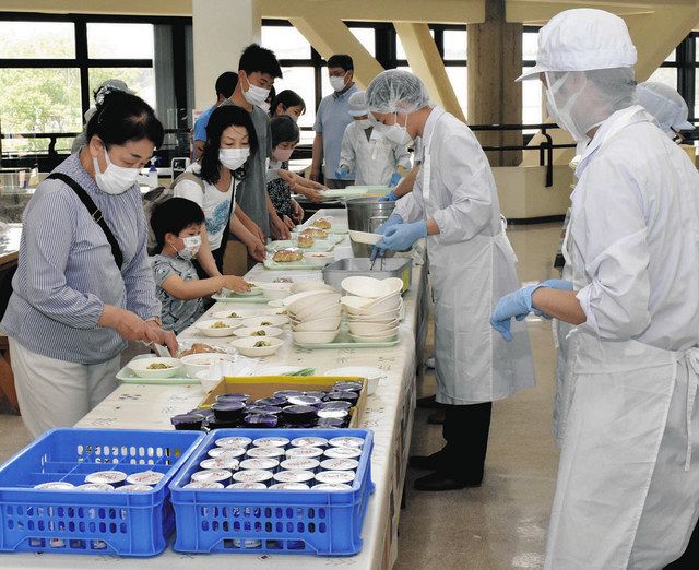 配膳台ではエプロン姿の職員が取り分けた給食をトレーに載せていく＝春日井市廻間町の市少年自然の家で