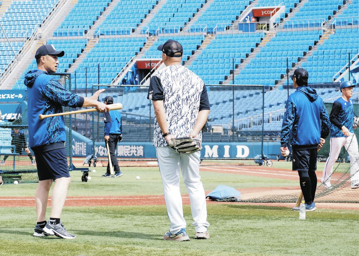 バットを手にチーム練習を見守るDeNA・相川監督（左）