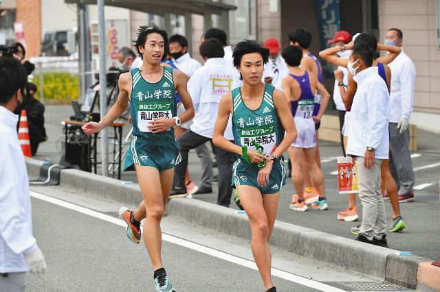 ７区を一位で終え、吉田圭太（右）にたすきを渡す青学大の神林勇太（代表撮影）