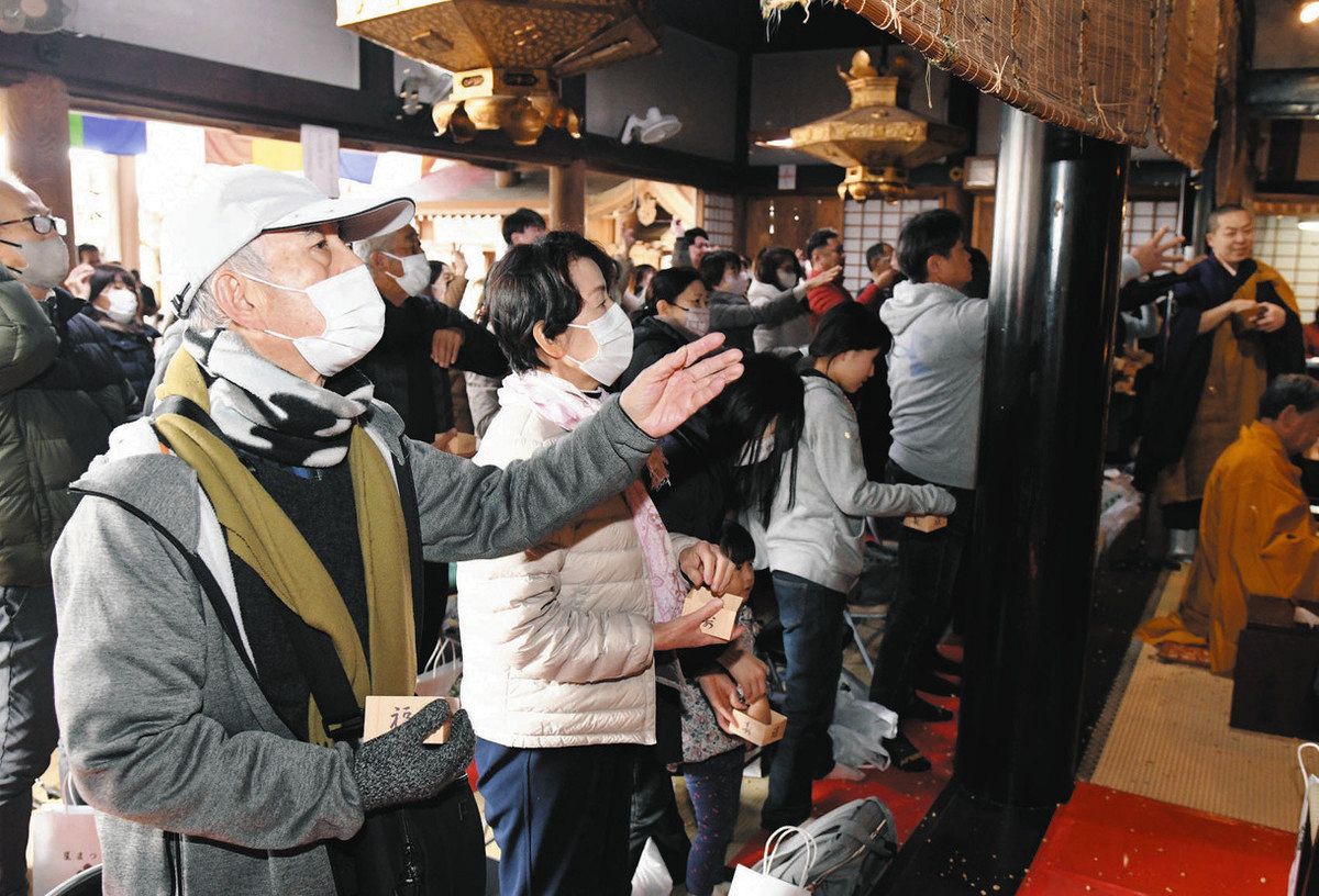 祈禱を受けて一斉に豆をまく人々＝岐阜市伊奈波通の善光寺安乗院で
