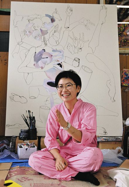 制作中の絵の前で自身について語る岩本さん＝松阪市小阿坂町の希望の園で 