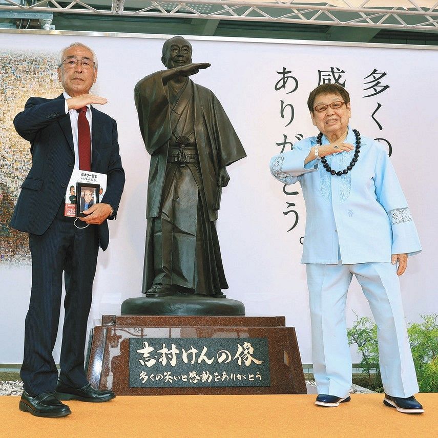 志村けんさんの銅像をはさみ、「アイーン」のポーズを決める兄の知之さん（左）と「ザ・ドリフターズ」の高木ブーさん