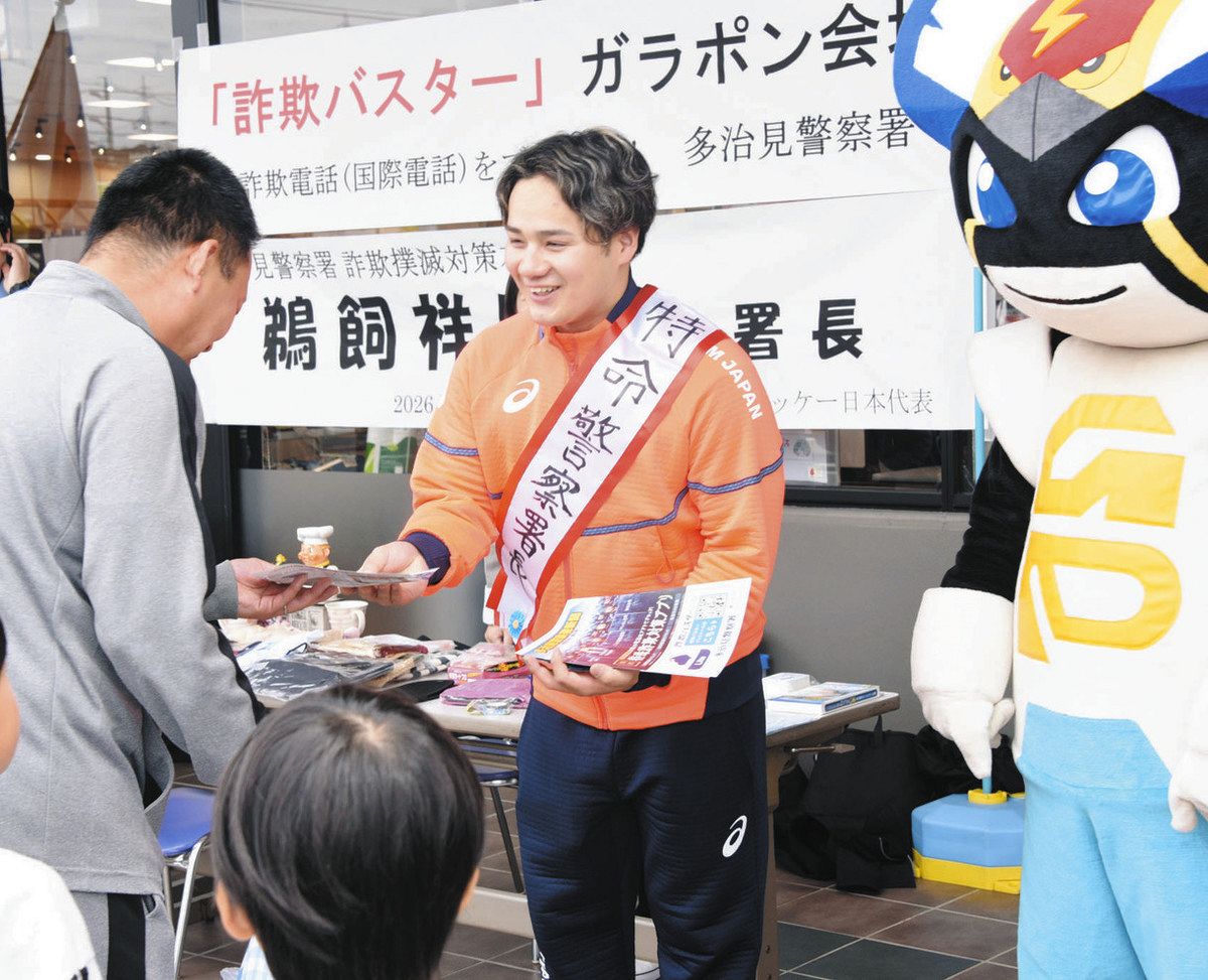 詐欺対策を啓発するちらしを来店客に手渡す鵜飼さん（右）＝多治見市若松町で