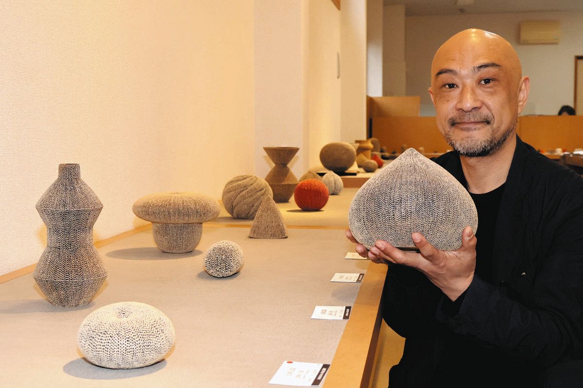 緻密な点刻文の作品などを並べた冨岡さん＝多治見市本町で