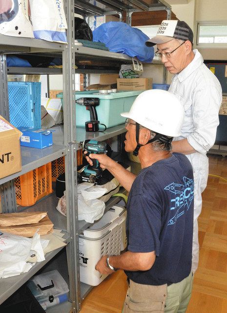 地震の際に棚が倒れないよう金具で固定する防災士ら＝２０１９年８月４日、中津川市第二中で