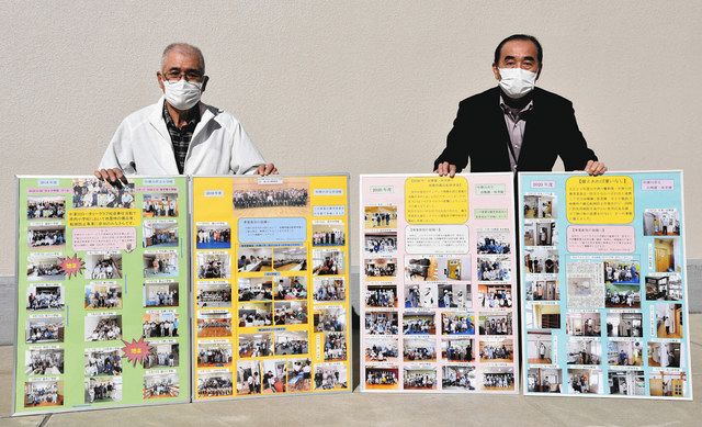 備品固定の取り組みをまとめたパネルを示す吉村さん（左）と杉山さん＝中津川市役所で