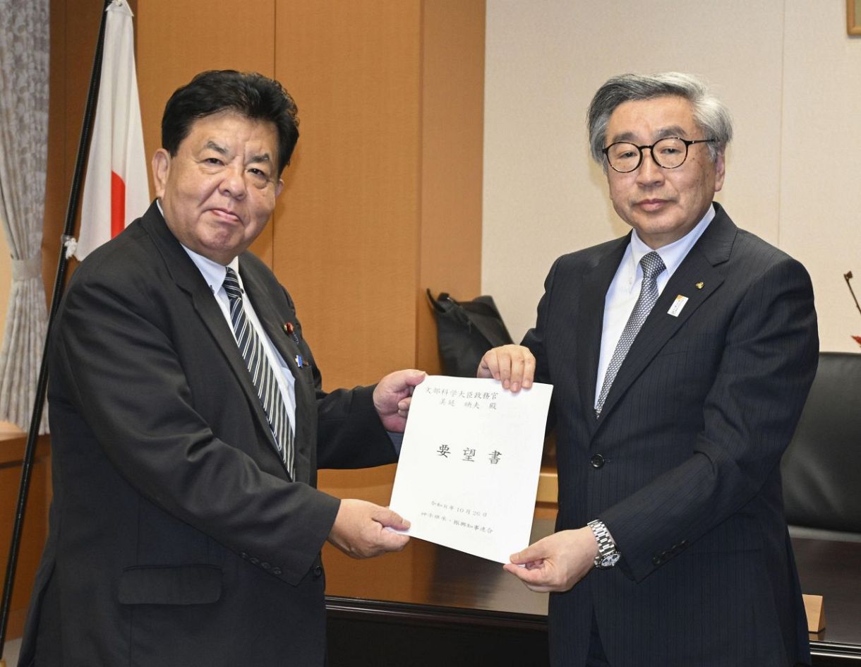 　美延映夫文科政務官（左）に要望書を手渡す「神楽継承・振興知事連合」の共同代表代理を務める日隈俊郎氏＝２６日午後、文科省