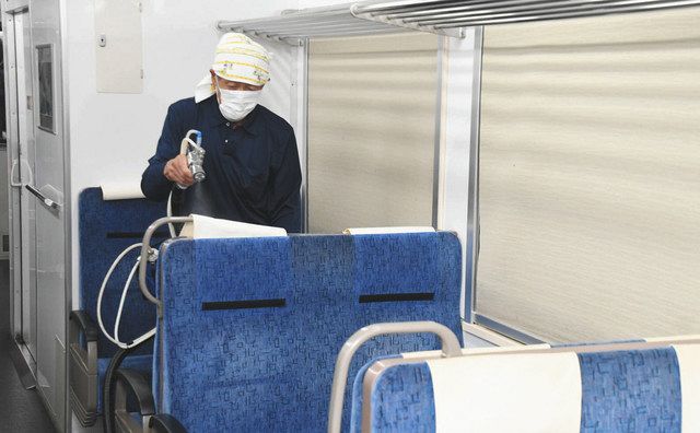 座席シートに光触媒の溶剤を噴霧する施工業者＝穴水町ののと鉄道穴水駅で 