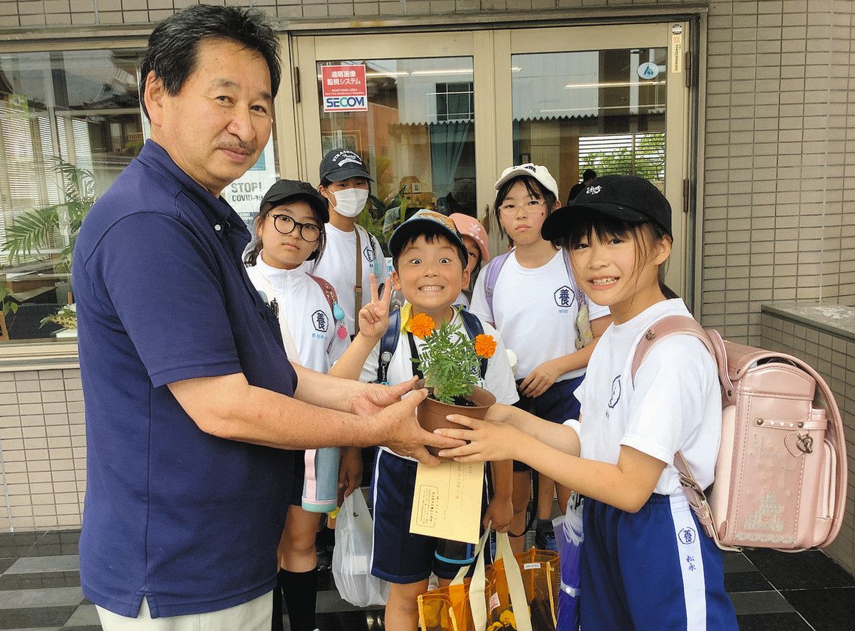 通学路の子ども110番の家に花を手渡す児童ら＝多治見市上町の佐々木陶器で（養正小提供）