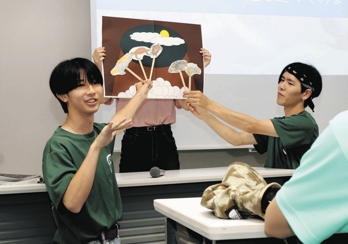 アカウミガメの生態を説明する三重大の公認サークル「かめっぷり」の学生＝津市白塚町の志登茂川浄化センターで
