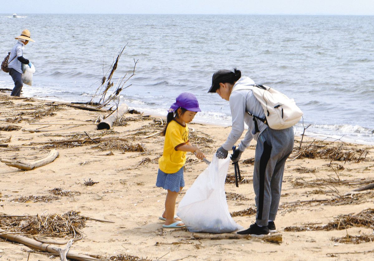 ウミガメを守るためごみを拾い集める岸岡さん親子＝津市白塚町の白塚海岸で
