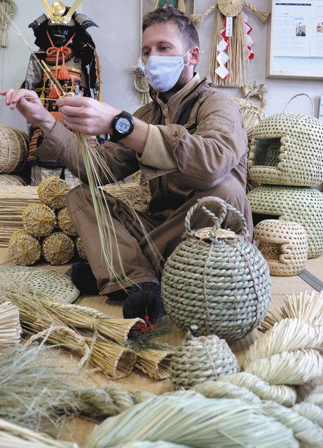 作業場でわらを綯うマイケルさん＝飯島町の未来いいじまで 