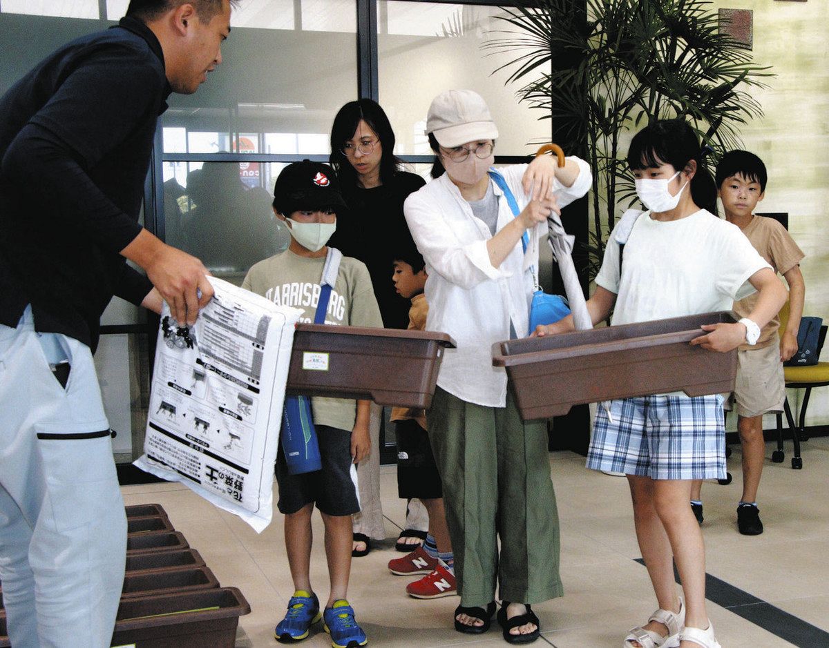 JA津安芸の職員（左端）からプランターや土などを受け取る参加者たち＝津市一色町のJA津安芸本店で

