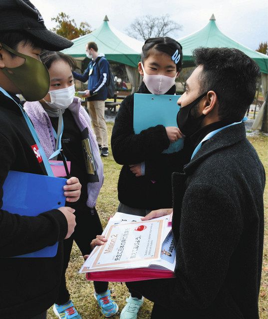 ＡＬＴの男性（右）と英語で会話を楽しむ児童たち＝竜王町川守の妹背の里で 