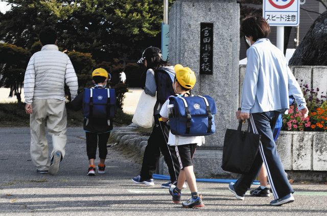 保護者と一緒に登校する児童ら＝宮田村の宮田小で 