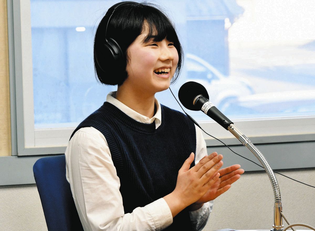 笑顔でラジオの生放送に挑んだ古根さん＝多治見市新町のFMピピで

