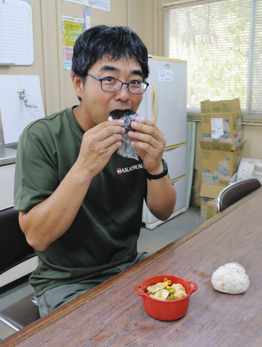 おにぎりをほおばる村松さん＝津市高野尾町で

