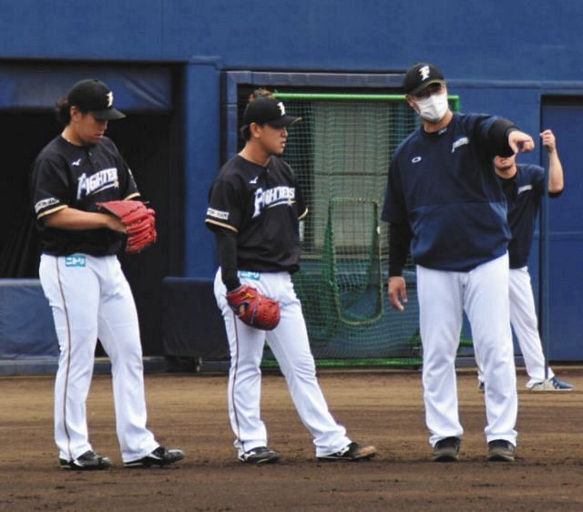 チーム練習で投手陣を指導する日本ハム・木田優夫投手コーチ（右端、球団提供）