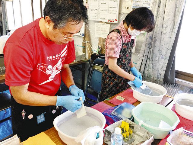 写真洗浄の作業に取り組む様子＝岡山県倉敷市真備町で　 