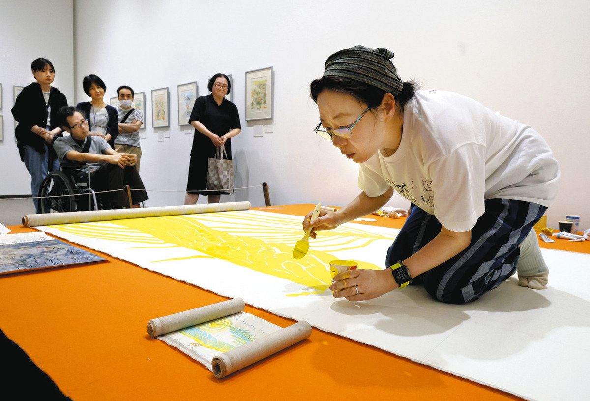 回顧展の会場でライブペインティングをするこうの史代さん＝２０日、金沢市の金沢２１世紀美術館で
