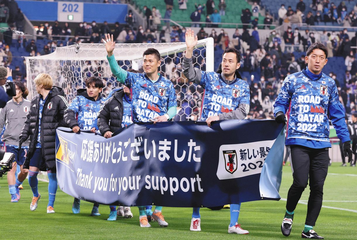 試合終了後、横断幕を掲げサポーターに手を振る日本代表イレブン