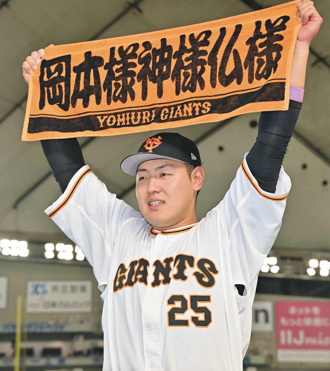 タオルを掲げ笑顔を見せる巨人・岡本和