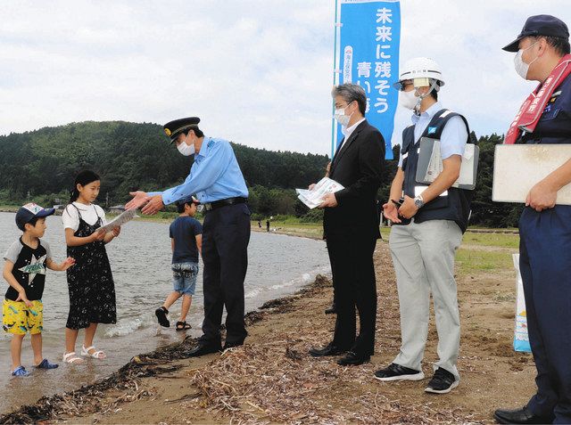 遊泳客に事故に気を付けるよう呼び掛ける関係者＝８月、七尾市能登島佐波町で 