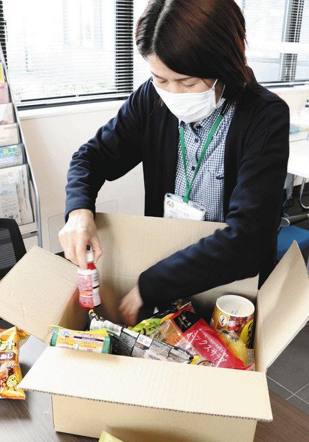 自宅療養者に届ける食料品セットを確認する市職員＝甲賀市役所で 