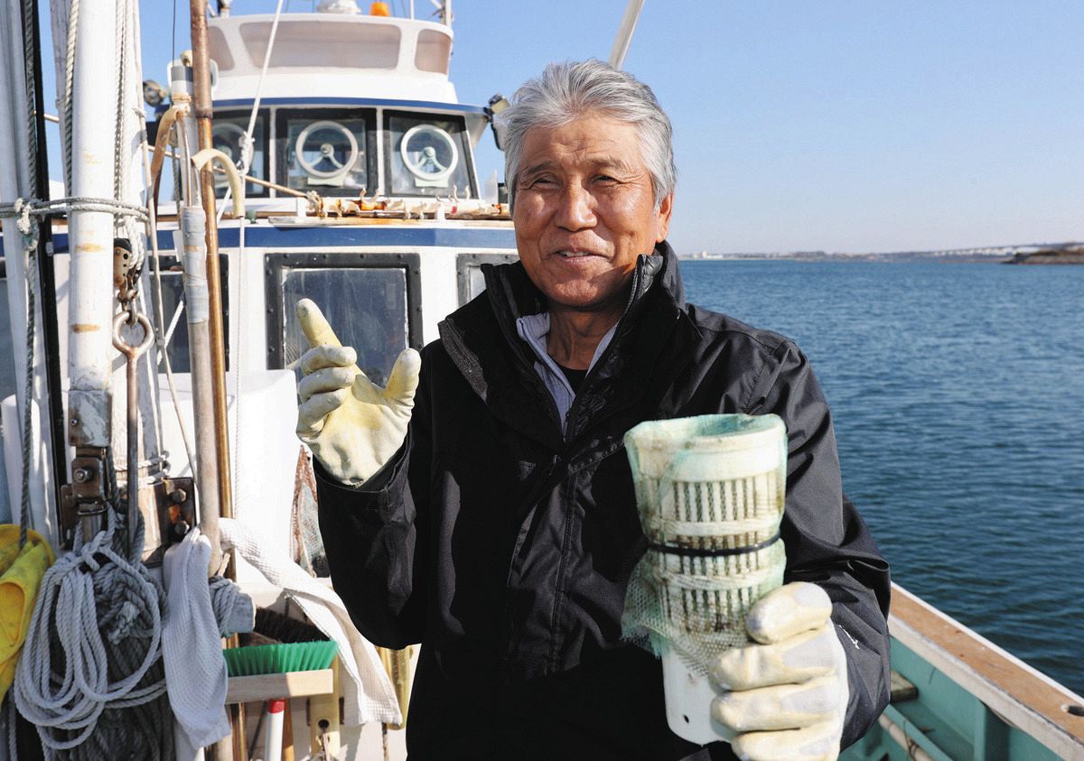 自作のマイクロプラスチック回収装置を手に「浜名湖をきれいにしたい」と話す徳増隆二さん＝湖西市新居町で
