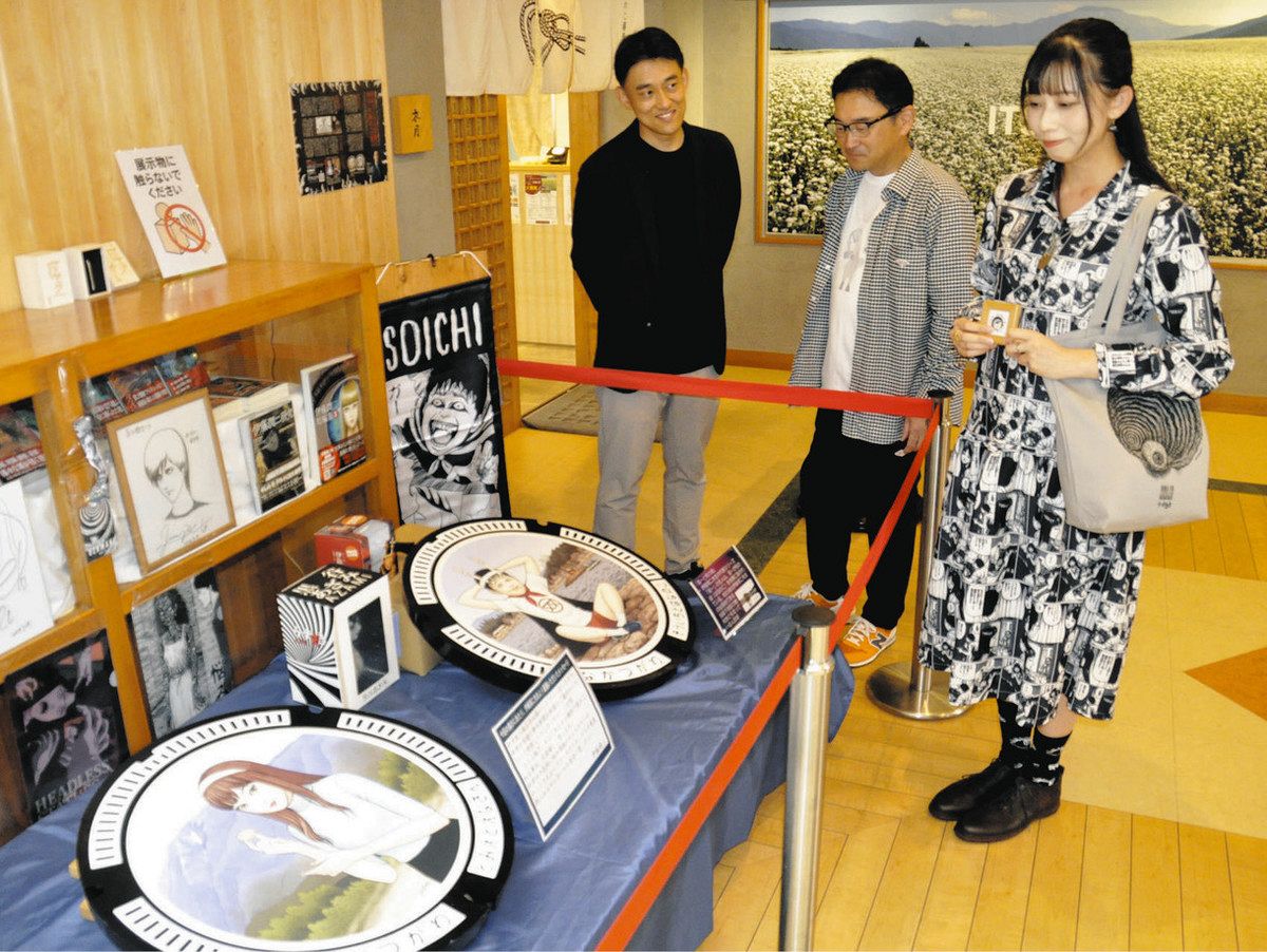 hanaさん（右）にマンホールを紹介する佐藤社長（左）と酒井社長＝中津川市坂下の道の駅きりら坂下で
